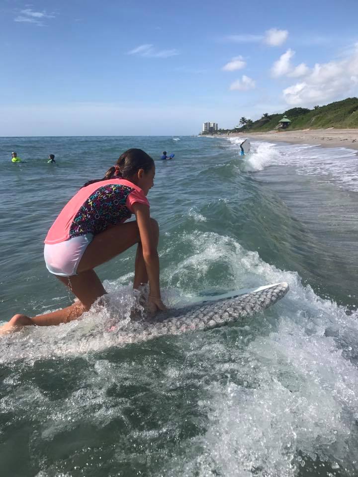 Camper riding a small wave on a board